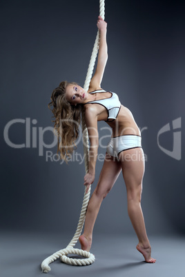 Gorgeous young model posing hanging on rope
