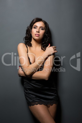 Languid brunette posing in black silk negligee