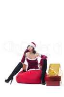 Sexy female Santa Claus posing with bag of gifts
