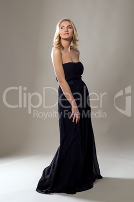 Smiling pretty blonde posing in long black dress