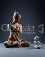 Image of sensual naked telekinetic with stones
