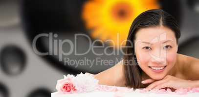 Composite image of relaxed woman lying on the massage table