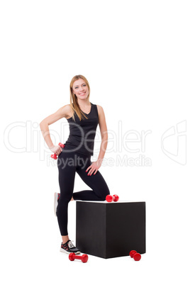 Smiling female athlete posing with dumbbells