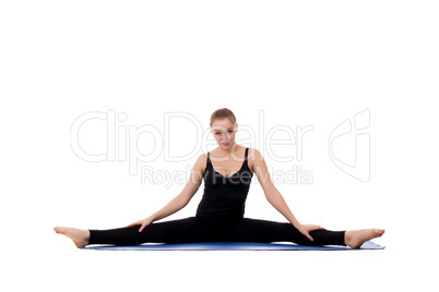 Beautiful young girl doing gymnastic splits on mat