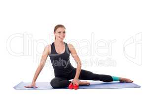 Fitness trainer sitting on mat with dumbbells