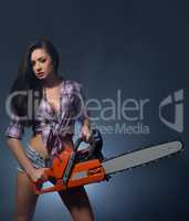 Tempting young woman posing with chainsaw