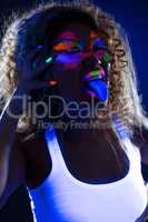 Image of funny girl posing at camera in UV light