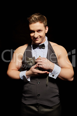 Smiling handsome male dancer palming kitten