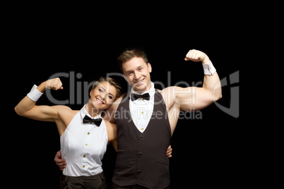 Smiling dancers shows biceps, isolated on black