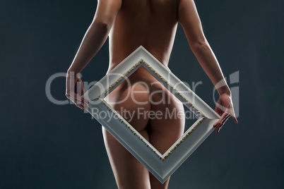 Bare woman's ass framed, on gray backdrop