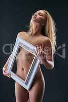 Concept of self-love. Naked girl holding frame