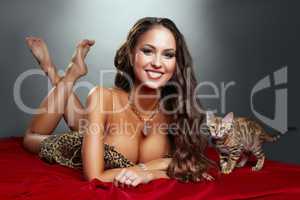Woman in leopard print negligee posing with cat