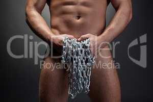 Close-up of naked strong man posing with chain