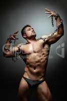 Handsome muscled male dancer breaking chain