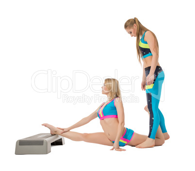 Pretty female gymnasts warming up in studio