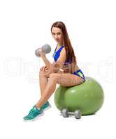 Cute female athlete exercising with dumbbells