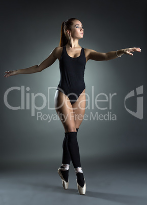 Pretty ballerina dancing gracefully in studio