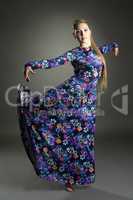 Lovely female dancer posing in colorful long dress