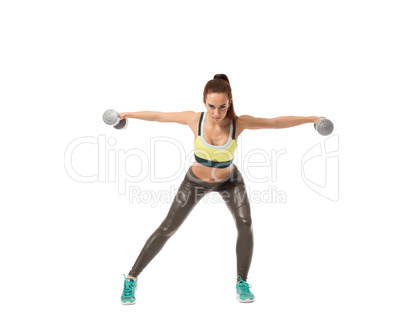Harmonous girl training with dumbbells at camera