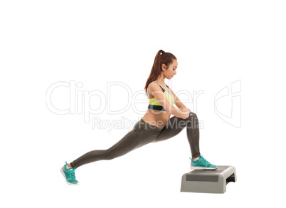 Beautiful athletic girl exercising on stepper
