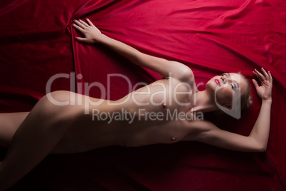 Fascinating girl posing nude on satin bedsheet