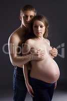 Pregnant topless woman posing with her husband