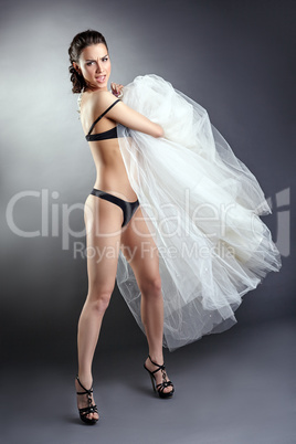 Pretty undressed girl posing with wedding dress
