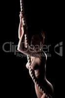 Skinny nude girl posing with rope in studio
