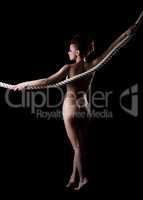 Rear view of nude woman posing with rope