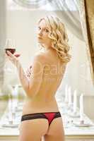 Beautiful topless blonde with glass of red wine