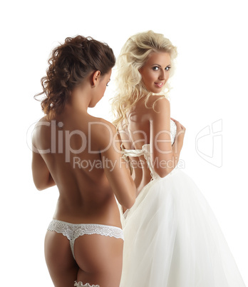 Seductive topless girl helps bride to wear dress