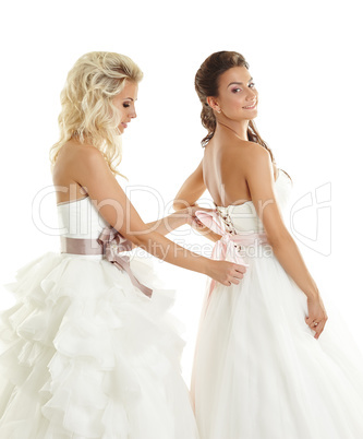 One of brides helps other to lacing corset