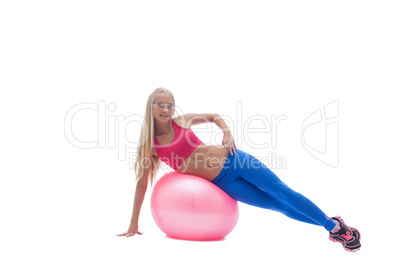 Smiling blonde posing exercising on fitness ball