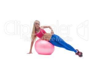 Smiling blonde posing exercising on fitness ball
