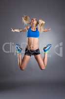 Image of cheerful fitness girl posing in jump
