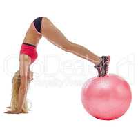 Energetic girl doing handstand on fitness ball