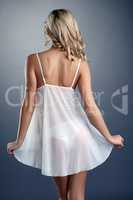 Rear view of slim tanned blonde in negligee