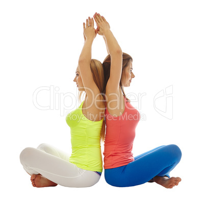 Pretty women practicing yoga in pair