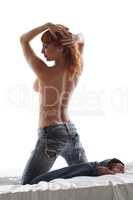 Red-haired model posing topless in jeans