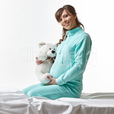 Happy expectant mother in casual clothes with toy
