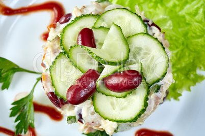 Delicious salad decorated with cucumber and beans