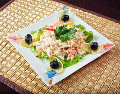 Tasty salad decorated with olives on skewers