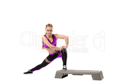 Grinning girl doing shaping exercise on stepper