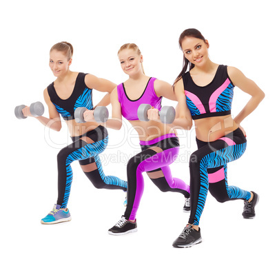 Smiling female athletes posing with dumbbells