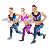 Smiling female athletes posing with dumbbells