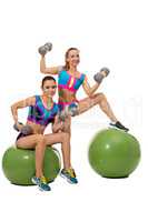 Two smiling girls exercising with dumbbells