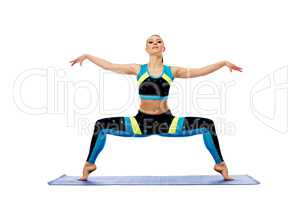 Attractive young woman engaged in pilates on mat