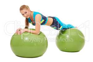 Beautiful girl posing laying on fitness balls