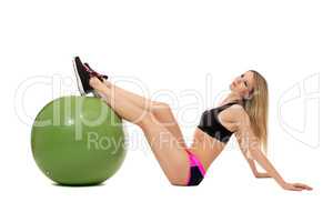 Dreamy sporty girl threw her feet on fitness ball
