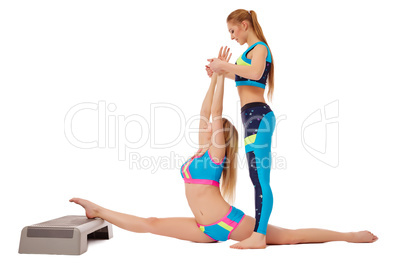 Beautiful girls doing stretching exercise in pair
